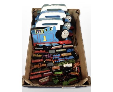 A group of Thomas the Tank Engine locomotives and carriages, in plastic boxes.