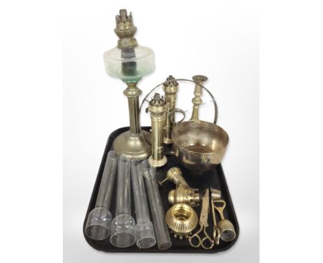 An early 20th-century brass oil lamp base with clear glass reservoir, together with further continental brass oil lamps, cand