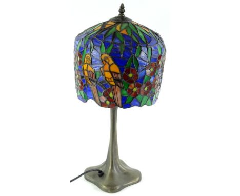 A Tiffany style lamp, the shade decorated with birds, flowers, etc., on a simulated bronze base 52cm high. 