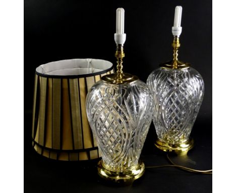 A pair of Waterford crystal baluster shaped lamp bases, each with gilt brass mounts and with cream and black shades, 50cm to 