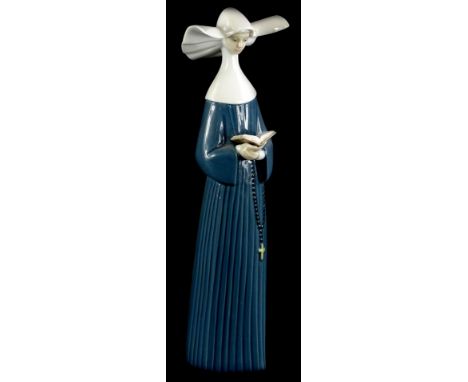 A Lladro porcelain figure of a nun, wearing a blue gown, numbered to underside 5500, 26cm high (boxed).