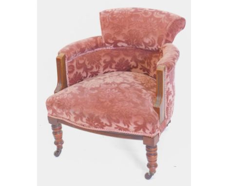 An Edwardian mahogany tub chair, upholstered in dark purple textured velvet, on turned legs with ceramic castors.