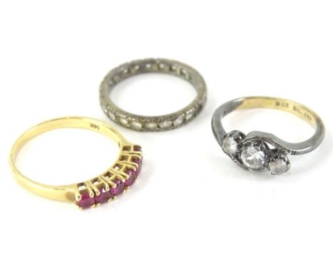 Three dress rings, comprising a ruby set half hoop eternity ring, yellow metal stamped 14K, with size round brilliant cut rub