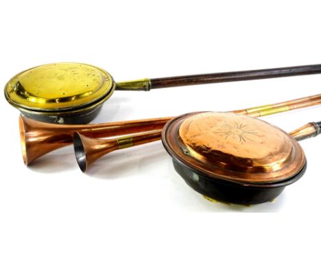 Two copper and brass hunting horns, a copper warming pan and a brass  warming pan, each with a turned wood handle.