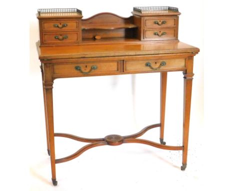 An Edwardian mahogany writing table, the raised back with two brass pierced galleries, two pairs of drawers, joined by a cent