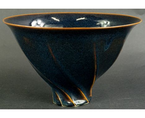 Chris Carter (b1945). A studio ceramic deep bowl, with wrythen shape, glazed in blue and mottled black glaze, circular mark t