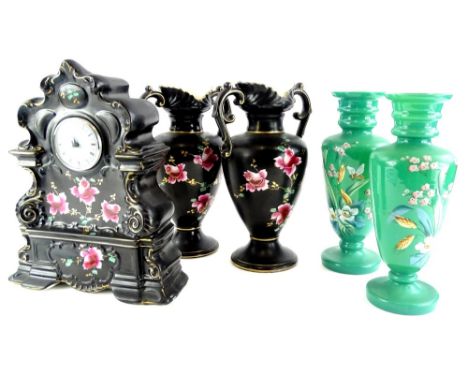 A late 19thC Staffordshire pottery clock garniture, comprising mantel clock decorated with roses on a black and gilt ground a