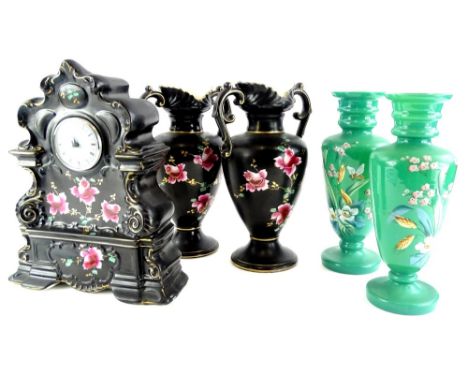 A late 19thC Staffordshire pottery clock garniture, comprising mantel clock decorated with roses on a black and gilt ground a