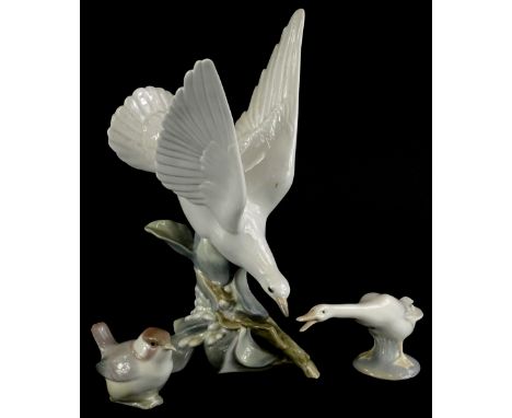 Three Lladro birds, to include a dove, seated on a branch of blossom, a wren and a goose.