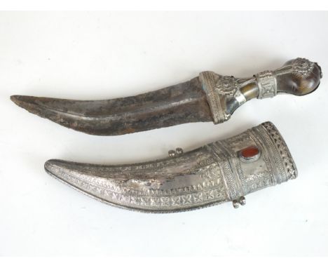 An Arabic white-metal mounted jambiya with horn hilt, the curved broad blade with raised medial ridge, characteristic white m