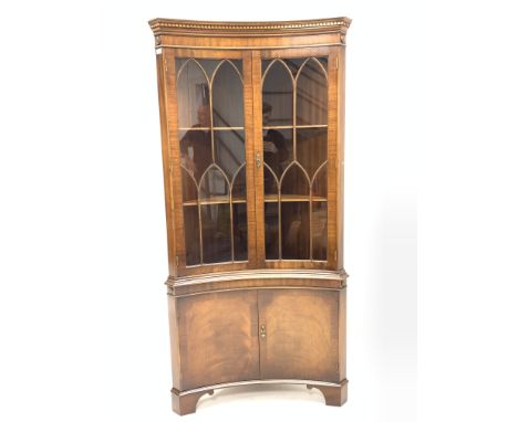 Georgian style mahogany concave fronted corner cabinet, with dentil cornice over astragal glazed doors enclosing two shelves,