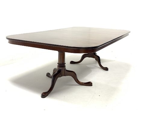 Late 20th century well figured mahogany twin pedestal dining table, the top raised on ring turned pedestals and triple splay 