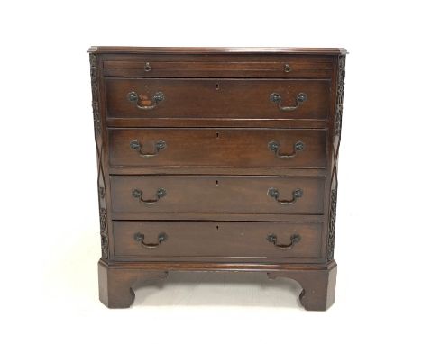 Early 20th century walnut chest, with brushing slide over four drawers, canted corners with applied carved detail, raised on 