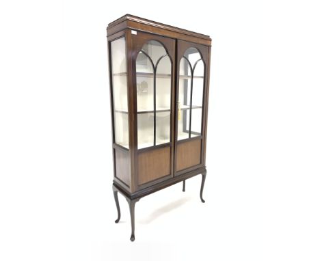 Early 20th century mahogany display cabinet, with caddy top over two tracery glazed doors enclosing three shelves, raised on 