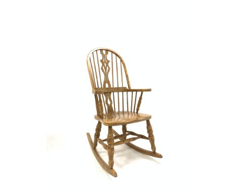 20th century elm Windsor style rocking armchair, hoop back with spindles and pierced splat over saddle seat and turned suppor