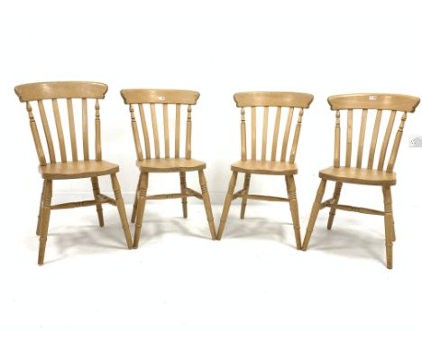 Set four beech wood Windsor style comb back dining chairs, with shaped seats raised on ring turned supports united by stretch