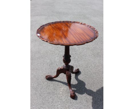 A Georgian style mahogany carved tripod table, the top with a pie crust edge