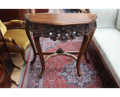 A reproduction oak and beech console table, the frieze carved in high relief