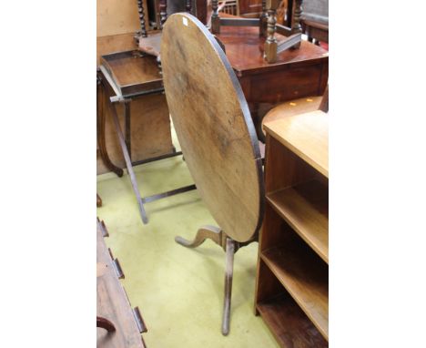 A George III oak tripod table, the circular top raised on a turned column