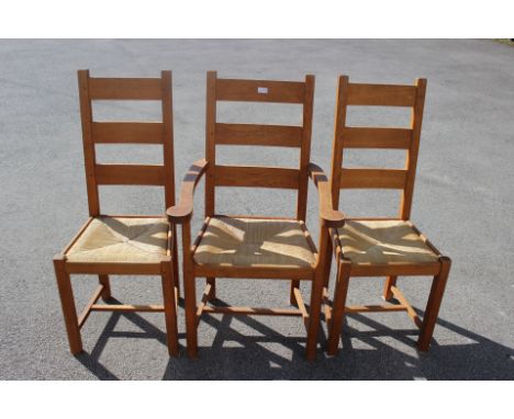A set of ten contemporary oak ladder back chairs, comprising two carver chairs and eight side chairs, with rush seats (10)