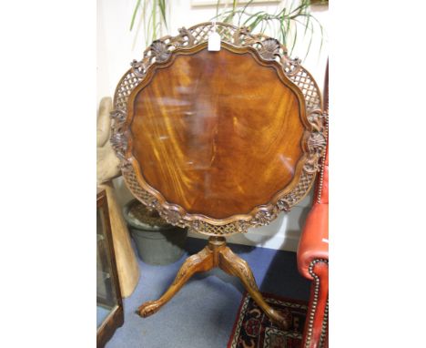 A Georgian style mahogany carved tripod table, the tilting top with a bird-cage mechanism, pie crust edge