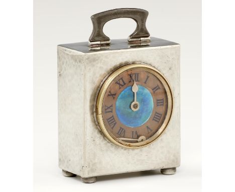 A LIBERTY &amp; CO PEWTER TIMEPIECE, C1903&nbsp; the lightly hammer textured bale shaped case inset with copper dial with tra