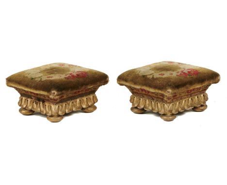 A PAIR OF VICTORIAN&nbsp; GILTWOOD FOOTSTOOLS, C1850 of square shape covered in contemporary floral carpet above lapet carved