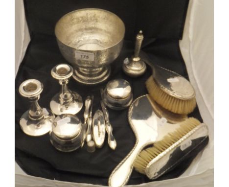 A pair of silver mounted candlesticks, a pair of silver lidded glass dressing table jars, a three piece silver back dressing 