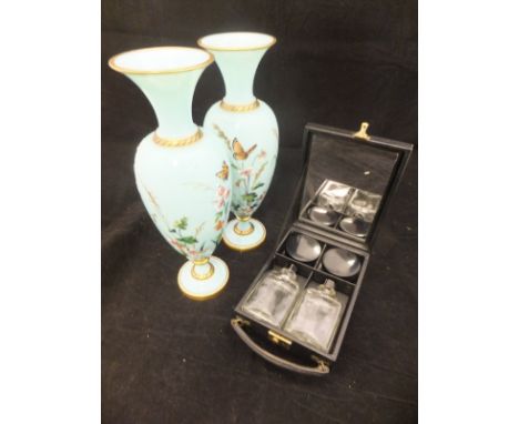 A pair of turquoise glass baluster shaped vases painted with flowers and butterflies on a circular gilt and bead decorated fo