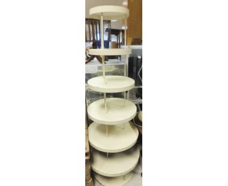 A cream painted iron six tier shop display stand, together with a turned and fluted standard lamp