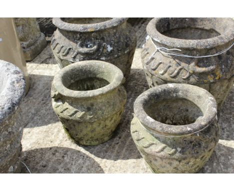 Two pairs of composite stone garden urns, each with stylised Celtic knot decoration