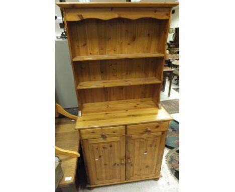 A late 20th Century pine dresser with two open shelves above a base of two drawers and two cupboard doors, together with a st