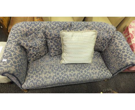 An early 20th Century drop arm two seat sofa in blue patterned upholstery, raised on cabriole front legs