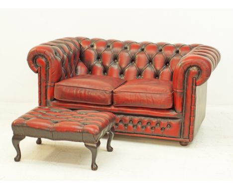 A chesterfield sofa, upholstered in burgundy buttoned natural soft leather, curved back and arms, with similar matching ottom