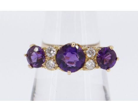 18CT GOLD SEVEN-STONE AMETHYST &amp; DIAMOND RING, the three amethysts separated by four small diamonds all in a scroll setti