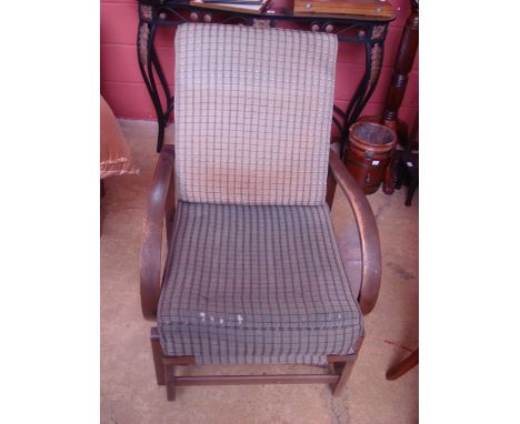 A 1930's reclining steamer armchair, with curved arms and fold out footrest, fitted with original cushions, bears label 'The 