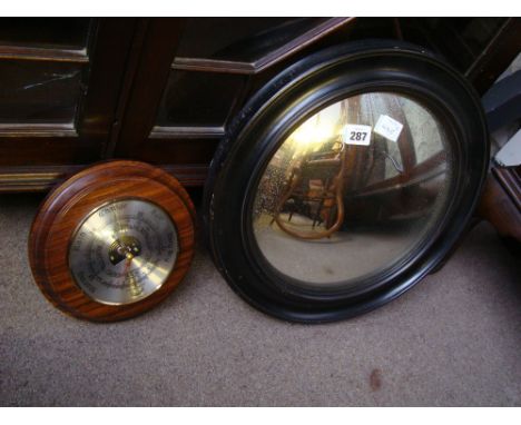 A circular convex mirror, in ebonised frame with a 20th Century aneroid barometer. 