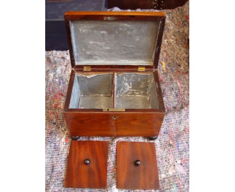 An early 19th Century rosewood tea caddy, the interior with two liddd compartments, raised ebonised compressed ball feet, wit