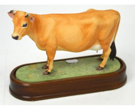 Royal Worcester; a figure of a 'Jersey Cow' modelled by Doris Lindner 1961, on fitted wooden plinth, height 19cm.