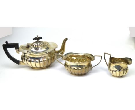 An Edward VII hallmarked silver three-piece tea service comprising a small teapot, sugar bowl, and milk jug, W Aitken, Cheste