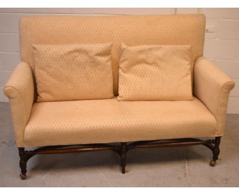 A Victorian mahogany-framed sofa, narrow scrolling arms to turned supports and curved cross-stretcher on castors, approx leng