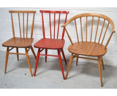 Three Ercol chairs; a Golden Dawn cow horn carver chair and two low stick dining chairs; one painted red, the other Golden Da