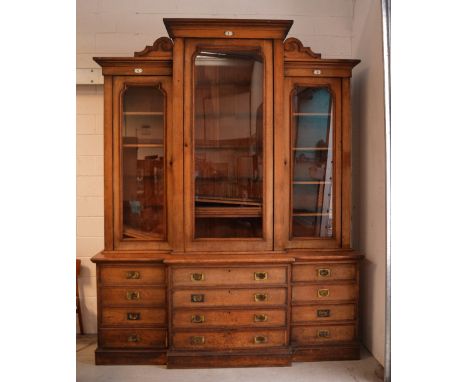 A late 19th century oak library break-front bookcase, large central glazed door flanked by two smaller glazed doors opening t