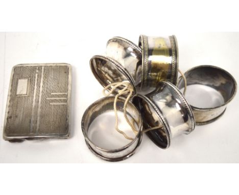 A white metal engine-turned compact marked verso 833, four hallmarked silver napkin rings, various marks and a plated example