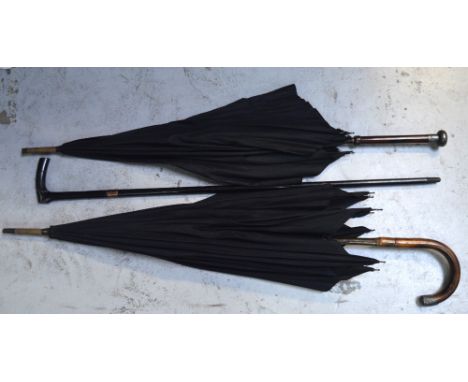 A 9ct rose gold mounted ebonised walking stick, a silver-mounted bamboo-handled black silk umbrella and a further similar exa