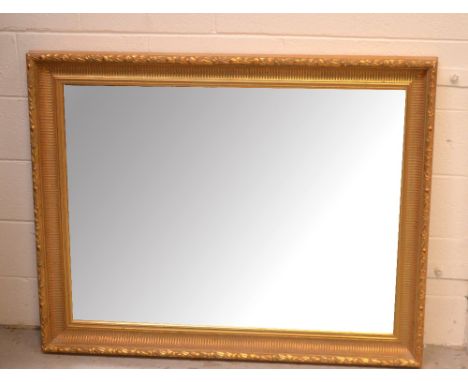A large contemporary gilt-framed wall mirror, bevelled glass and cushion-moulded, approx 116 x 93cm.