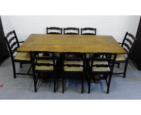 A nine piece oak dining suite comprising eight ladder back chairs and table (9) 