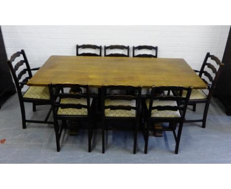 A nine piece oak dining suite comprising eight ladder back chairs and table (9) 