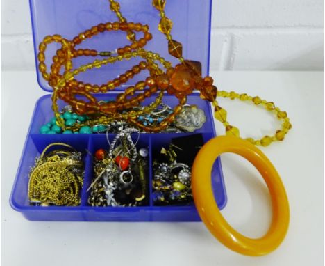 A quantity of amber coloured glass beads and a bangle, together with gilt metal chains, costume jewellery, earrings etc. (a l