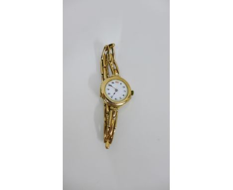 A Lady's 9 carat gold cased wristwatch, the white enamel dial with Arabic numerals, on a yellow metal expandable strap 